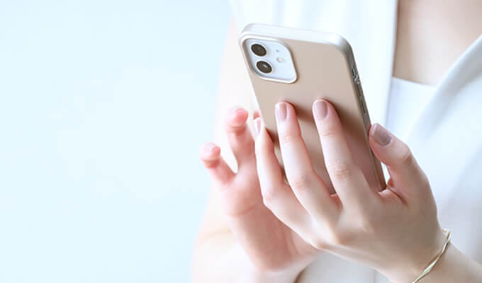 スマホでWeb予約をしている女性