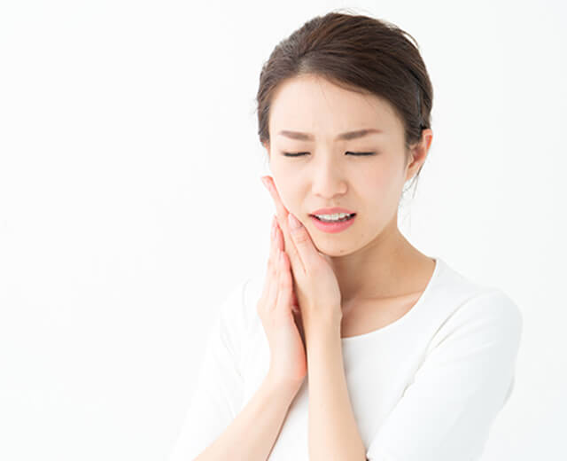 痛そうに頬を押さえている女性